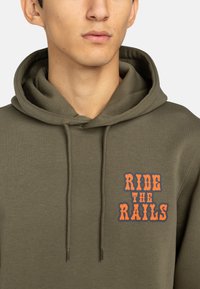Felpa verde oliva con cappuccio regolabile. Presenta la scritta "RIDE THE RAILS" in lettere arancioni e blu sul davanti.
