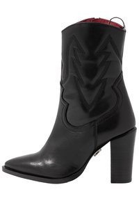 Bottine en cuir noir avec un bout pointu, un talon carré, des coutures décoratives et un intérieur en rouge.