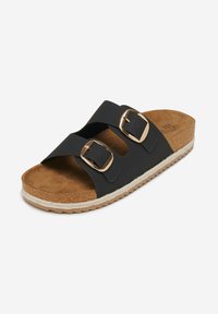 Black slide sandals with two adjustable straps, gold buckles, and a cork footbed. Features a textured rubber sole and a braided jute accent.