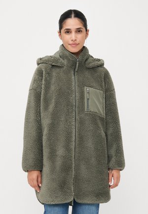 Manteau en vert olive, doublé en polaire, avec fermeture éclair, capuche et une poche poitrine en matériau contrasté. Dispose d'une coupe décontractée et d'une texture douce.