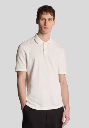 Polo bianco a maniche corte con un motivo testurizzato a nido d'ape e colletto classico, con un piccolo logo ricamato sul petto.