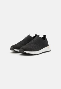 Black knit slip-on shoes with a textured upper, contrasting white midsole, and black rubber outsole featuring a textured grip pattern.
