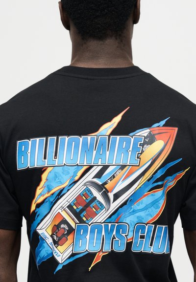 Άνδρας φοράει μαύρο T-shirt με πολύχρωμο γραφικό πυραύλου και το κείμενο «BILLIONAIRE BOYS CLUB» στην πλάτη.