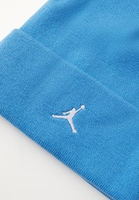 Berretto in maglia blu con texture a coste, dotato di un'accattivante logo Jumpman ricamato in bianco sulla parte anteriore.