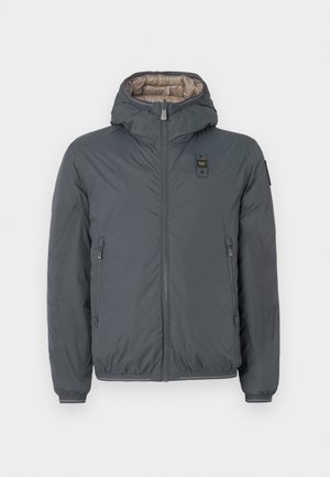 Chaqueta acolchada con capucha de color gris oscuro, con cierre frontal, bolsillos laterales con cremallera y un pequeño parche de logo en el pecho y la manga izquierda.