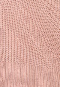 Pull en tricot dans un rose doux. Présente une texture côtelée et un motif avec des éléments horizontaux et verticaux. Large bande au bas.