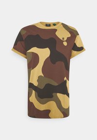 Camo t-shirt i bomull med oregelbundna former i brunt, grönt och gult, med rund halsringning och korta ärmar.