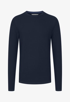 Mornarsko modra dolga majica iz teksturiranega materiala, s krožnim ovratnikom ter rebrastimi manšetami in robom. Preprost, brez okrasnih elementov.