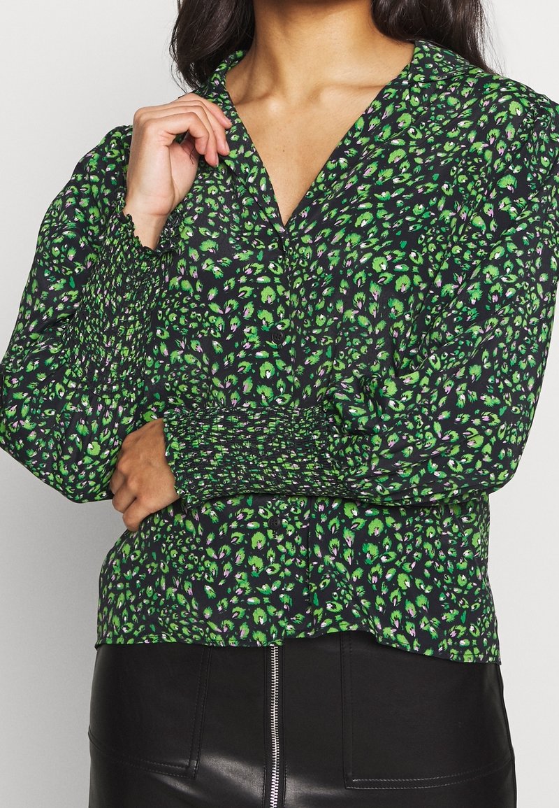 Green and purple floral patterned blouse with a v-neck, smocked sleeves, and a black background; soft fabric with casual fit.