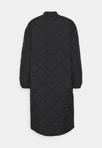 Abrigo acolchado negro con un corte largo y relajado, con un patrón de costura ondulada y puños elásticos. La tela parece suave y ligera.