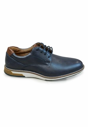 Zapato de cuero azul marino con un acabado suave, detalles en marrón claro, diseño de cordones y una suela texturizada con rayas blancas y marrones.