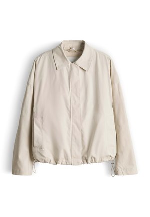 Giacca beige chiaro con collo a camicia, cerniera frontale, tasche laterali ed elastico all’orlo. Realizzata in tessuto liscio con finitura leggermente opaca.