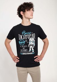 Sort bomulds t-shirt med "Buzz Lightyear" grafik, der har blå og hvid tekst, der viser en astronautkarakter og vingedesign.