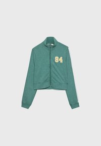 Felpa verde a zip con colletto alto, strisce bianche sui maniche e il numero "84" stampato sul petto.