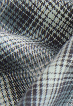 Tessuto intrecciato con un motivo pied de poule in tonalità di blu scuro e grigio chiaro, caratterizzato da una texture liscia e linee diagonali ben definite.