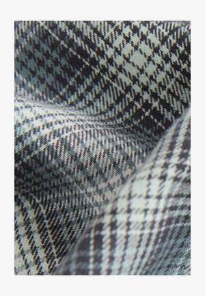 Tessuto intrecciato con un motivo pied de poule in tonalità di blu scuro e grigio chiaro, caratterizzato da una texture liscia e linee diagonali ben definite.