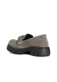 Mocassino in suede grigio con punta arrotondata, dettagli cuciti, accenti laterali e una spessa suola in gomma nera.