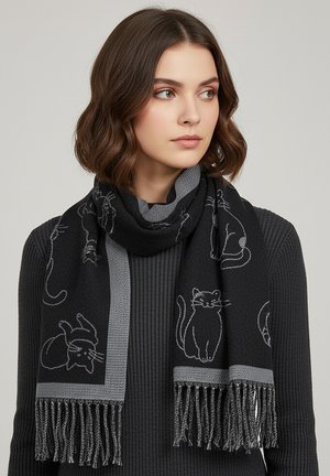 Black scarf featuring cat designs in gray, with a fringe edge. Made of a soft material, showcasing a textured, knitted appearance.