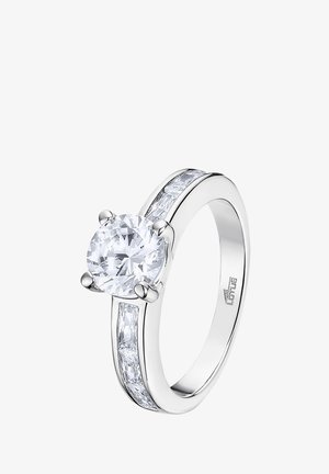 Bague en argent avec un large centre de pierre précieuse ronde et transparente, entourée de deux plus petites pierres rectangulaires de chaque côté, monture lisse et polie.