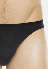 Black stretch fabric brief with a smooth texture, featuring a soft waistband and minimal coverage, designed for comfort and fit.