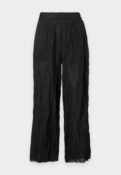 Pantalones de lino negros de pierna ancha con un acabado texturizado. Presentan una cinturilla elástica y pliegues sutiles.
