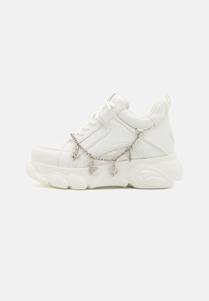 Valged sneakerid paksu tallaga, tekstureeritud nahast pealisosa ja dekoratiivne metallketti, millel on ripatsid. Omavad paeltega sulgemist ja pehmendatud kaela.