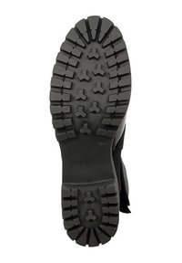 Czarna gumowa podeszwa buta z głębokimi rowkami i kanciastymi wzorami; ma gładką powierzchnię w pobliżu pięty i szeroką, teksturowaną powierzchnię uchwytu.