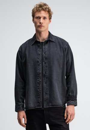 Donkergrijs denim overhemd met een knoopsluiting aan de voorkant, een spread collar en lange mouwen. Het heeft subtiele stiksels en een relaxte pasvorm.