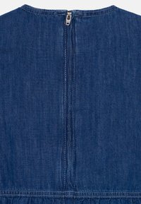 Denimkjole med glidelås på baksiden, har en jevn tekstur, mørk blå farge, diskret søm og en samlet nederkant.