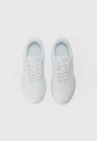 Baskets athlétiques blanches en maille et en matériau synthétique. Bout arrondi, lacets plats, talon rembourré, avec logo sur le côté.