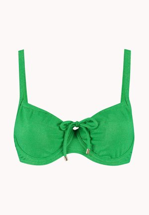 Haut de bikini vert avec bretelles ajustables et nœud devant avec embouts métalliques, sur un fond clair uni.