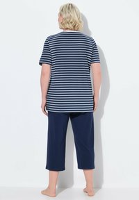 T-shirt a righe navy con maniche corte abbinato a pantaloni cropped navy. Tessuto morbido, vestibilità comoda e design semplice senza motivi visibili.