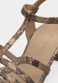 Πέδιλο με λουράκια από καφέ δέρμα με σχέδιο φίδι και μπεζ μαλακή εσωτερική σόλα, με λουράκι αστραγάλου και τακούνι block.