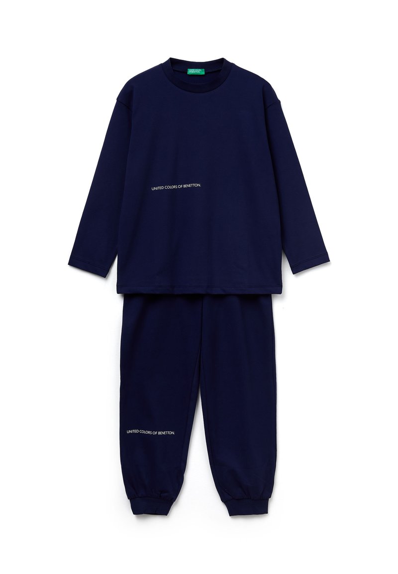 Tmavě modrý svršek z měkké tkaniny. Dlouhý rukáv s kulatým výstřihem a bílým logem na hrudi a kalhotách.