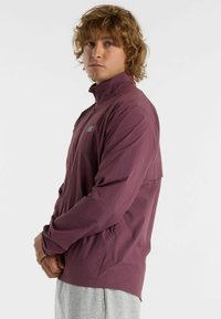 Maroon lightweight jacket with a stand-up collar, zippered front, and elastic cuffs. Features subtle logo on the left chest.
