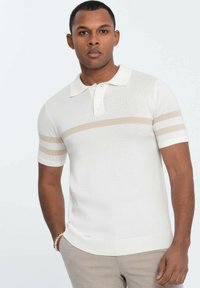 Polo tričko s krátkým rukávem v off-white barvě, s texturovaným pletením, tříknoflíkovou légou a vodorovnými béžovými pruhy na rukávech.