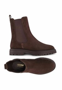 Brązowe zamszowe buty Chelsea z elastycznymi panelami bocznymi, pętlą z tyłu i wytrzymałą gumową podeszwą, przedstawione w widokach z boku i z góry.