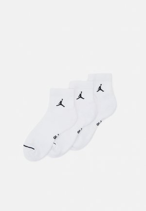 Bele nogavice do gležnjev v paketu po tri, z logotipi Jordan v črni barvi na straneh. Narejene so iz gladkega materiala s mešanico bombaža.