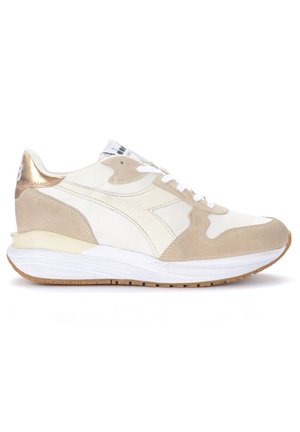 Sneaker beige e bianco con tomaia in suede e pelle, punta tonda, suola intermedia bianca spessa e dettagli metallici dorati sul tallone.