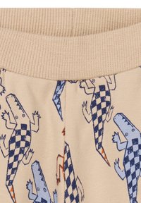 Shorts en tissu beige ornés d'un motif à carreaux illustrant des crocodiles en bleu et orange. Taille élastique avec texture côtelée.