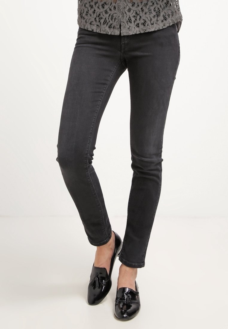 Svarta skinny jeans i bomullsblandning, med en slät yta och subtil elastiskhet. Kombinerade med glänsande svarta loafers.
