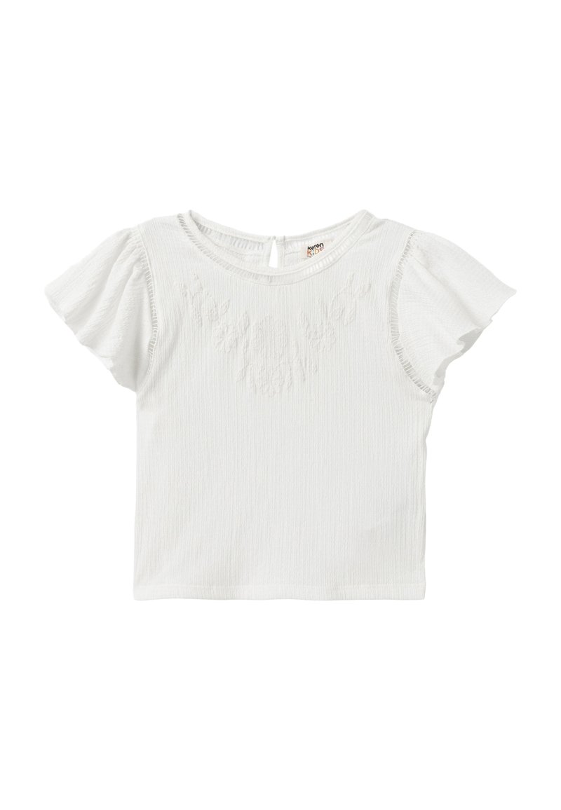 Top blanco de manga corta con tela texturizada, que presenta un escote redondo y mangas ligeramente rizadas. Bordado floral sutil en la parte frontal.