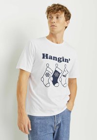 Bjela pamučna majica s mornarskoplavim printom na kojem piše "Hangin'" te s tri čarape, od kojih je jedna s motivom pahulje, a druga s motivom hollyja. Ležeran kroj.