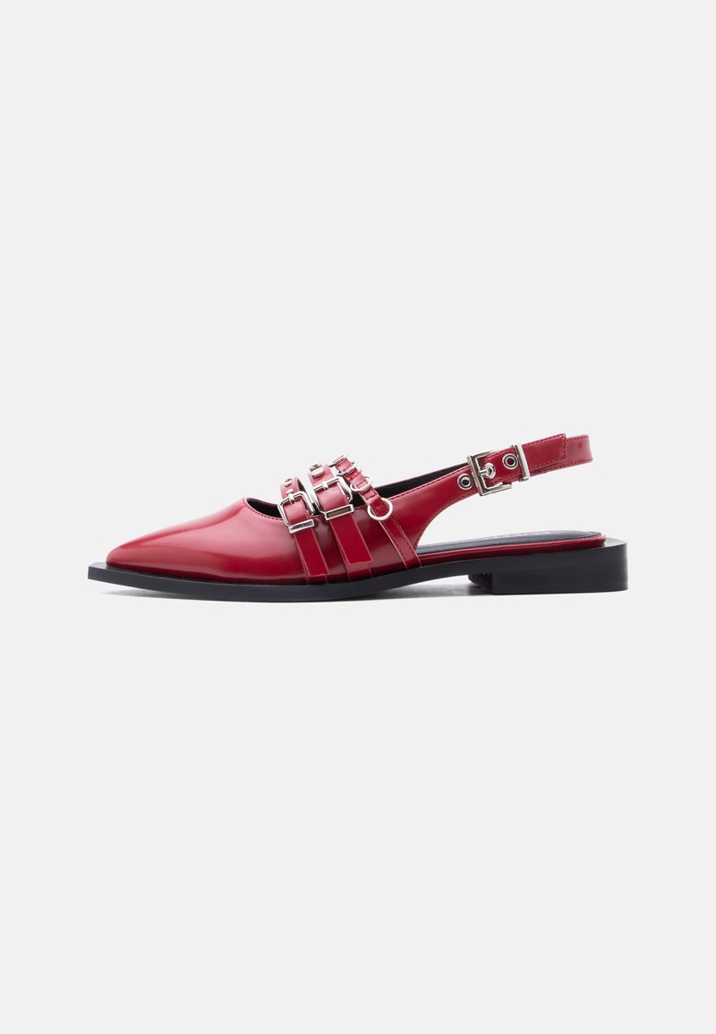 Κόκκινο επίπεδο παπούτσι slingback με τρεις ασημένιες αγκράφες και χαμηλό μαύρο τακούνι σε λευκό φόντο.