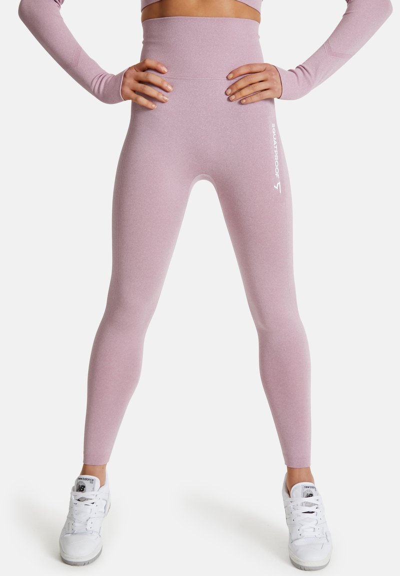 Korkeavyötäröiset legginsit pehmeästä vaaleanpunaisesta kankaasta, jossa on sileä pinta. Sivussa on valkoinen "SQUATPROOF" logo ja muotoiltu, joustava design.