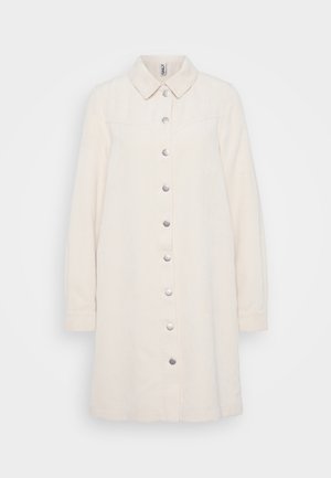 Abito button-up in corduroy beige chiaro con colletto, maniche lunghe, texture a coste verticali e bottoni a pressione metallici lungo la parte frontale.