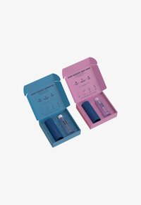 Ensemble de récupération sportif avec gel douche bleu et spray corporel rose. Chacun dans une boîte colorée, présentant les détails du produit et des bouteilles texturées.