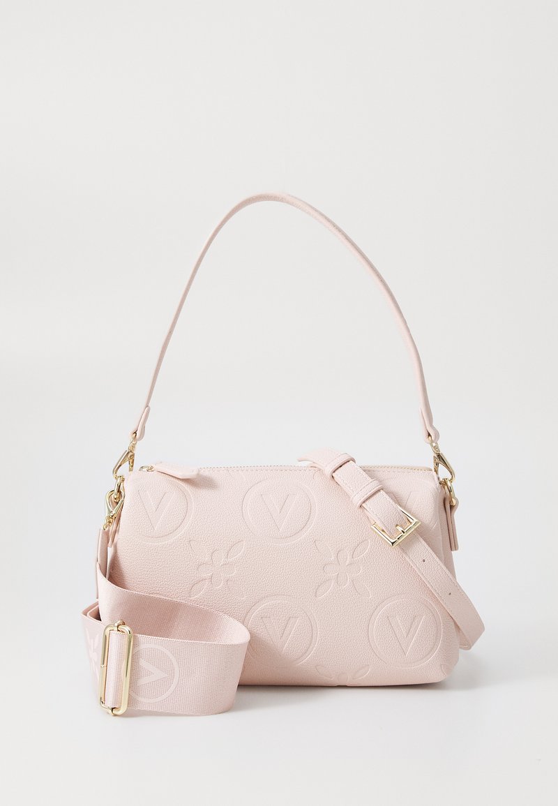 Sac à main en simili cuir rose avec des motifs floraux et logo en relief, matériel doré, bandoulière ajustable et fermeture zippée. Forme rectangulaire compacte.