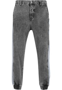 Pantalones jogger de mezclilla negra con bandas laterales en azul claro, puños elásticos, detalles desgastados y un diseño clásico de 5 bolsillos.