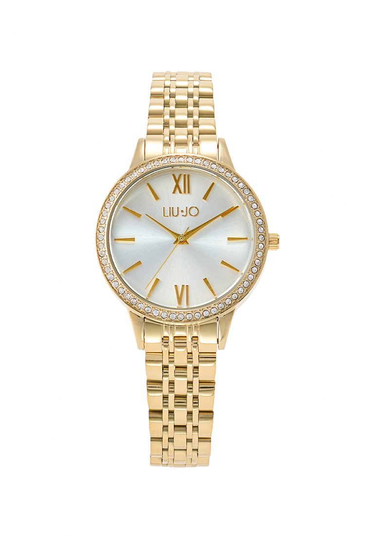 Orologio dorato con quadrante rotondo, quadrante argentato, numeri romani e dettagli in cristallo. Presenta un bracciale metallico con design intrecciato.